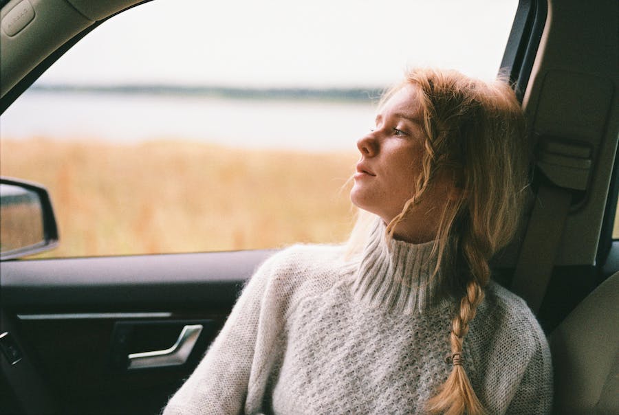 Kobieta ubrana w ciepły sweter w samochodzie